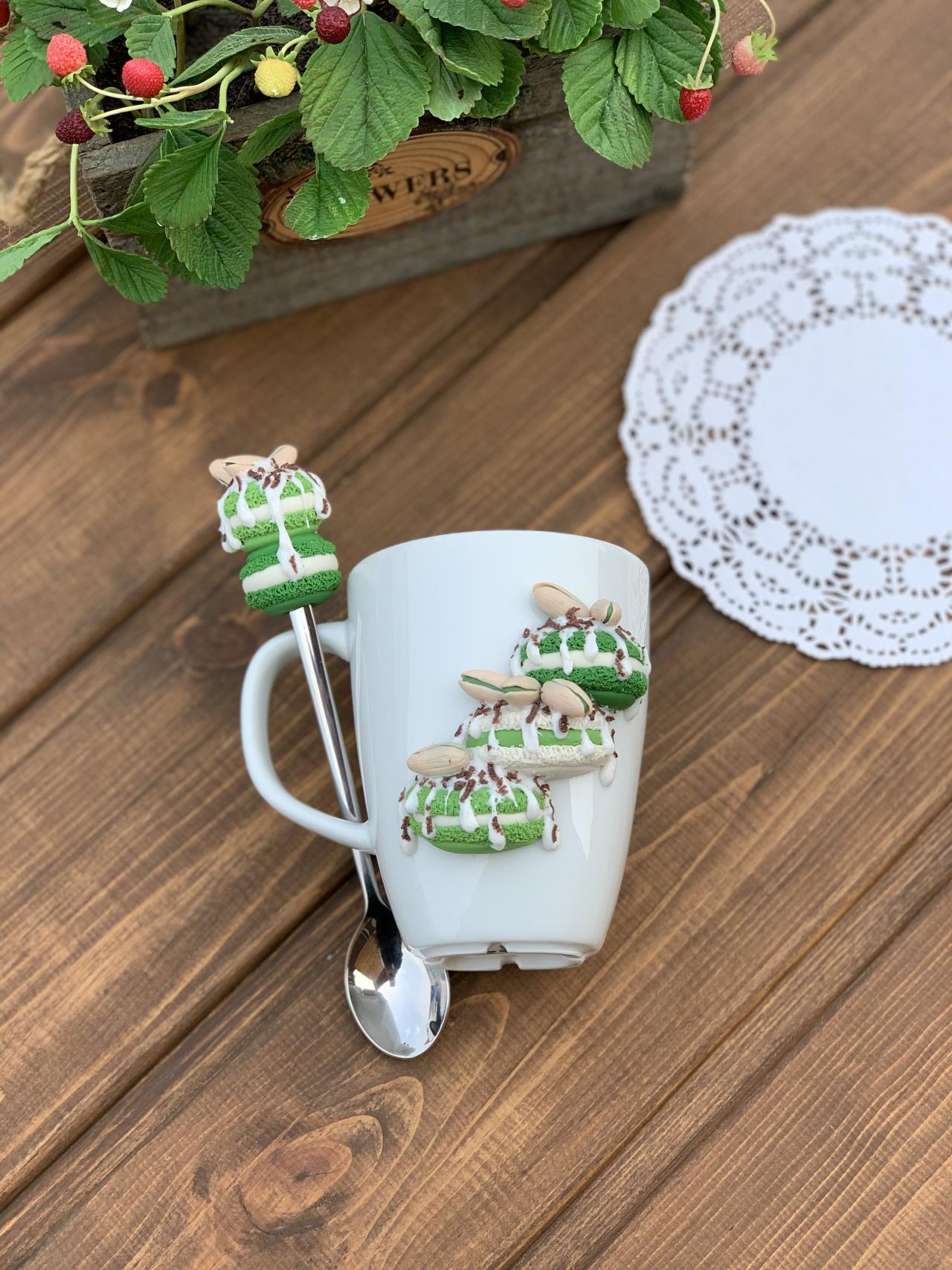 White cup for tea, Sweet mug and decor spoon, macaroons on the mug, delicious spoon with berries, green decor, sweet cookies.